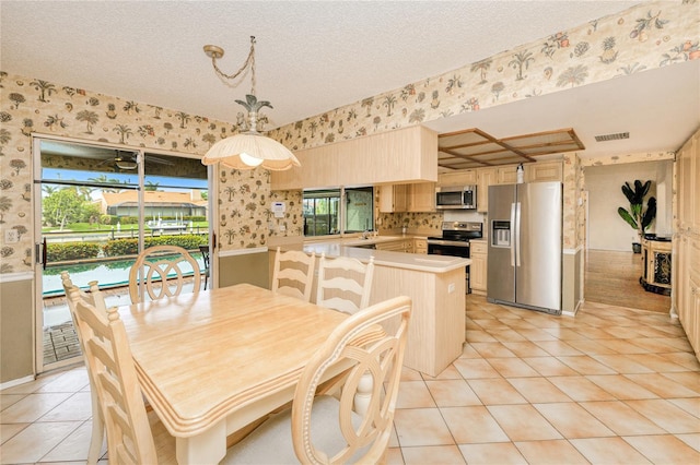 2160 Aqui Esta Dr, Punta Gorda, FL 33950 - dining area with wallpapered walls, light tile patterned flooring, a textured ceiling, and wainscoting