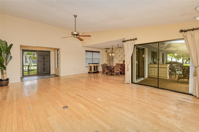 2160 Aqui Esta Dr, Punta Gorda, FL 33950 - unfurnished living room with a ceiling fan, wood finished floors, plenty of natural light, a textured ceiling, and baseboards