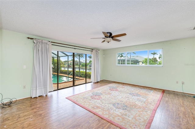 2160 Aqui Esta Dr, Punta Gorda, FL 33950 - spare room with a ceiling fan, wood finished floors, a textured ceiling, and baseboards