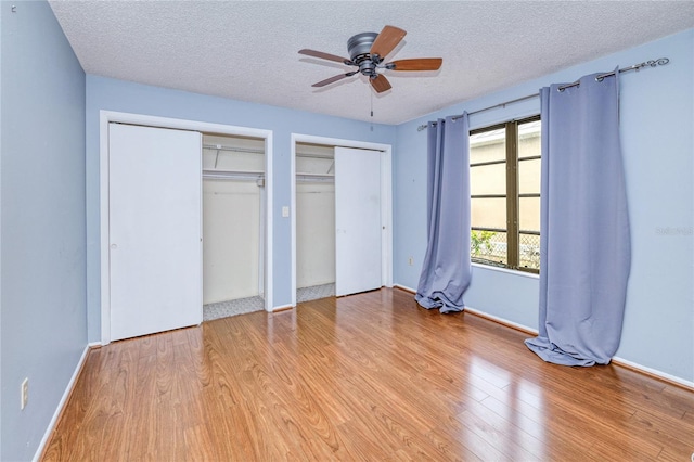 2160 Aqui Esta Dr, Punta Gorda, FL 33950 - unfurnished bedroom featuring multiple closets, light wood-type flooring, a textured ceiling, and baseboards