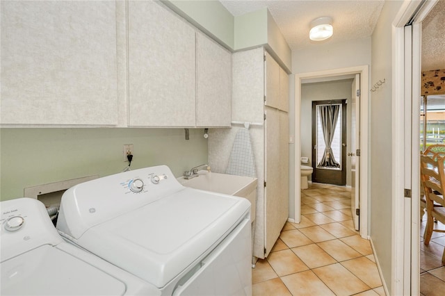 2160 Aqui Esta Dr, Punta Gorda, FL 33950 - laundry room with cabinet space, washing machine and clothes dryer, light tile patterned flooring, and a textured ceiling