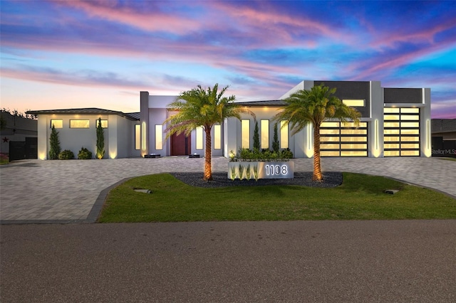 1108 SW 24th St, Cape Coral, FL 33991 - modern home featuring decorative driveway, a garage, stucco siding, and a front lawn
