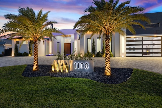 1108 SW 24th St, Cape Coral, FL 33991 - view of front facade featuring decorative driveway, stucco siding, a front lawn, and a garage