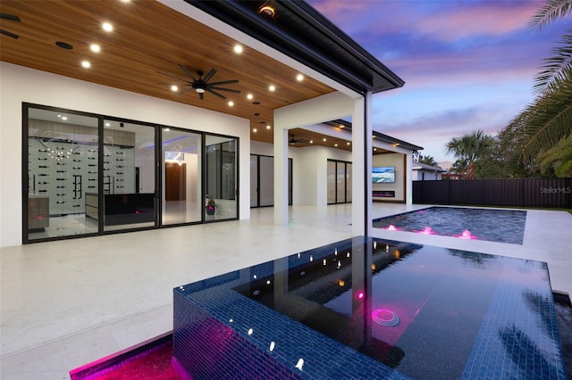 1108 SW 24th St, Cape Coral, FL 33991 - pool at dusk with ceiling fan, a patio, and a hot tub