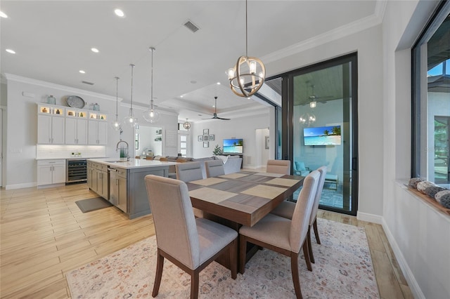 1801 Los Alamos Dr, Punta Gorda, FL 33950 - dining room with beverage cooler, ceiling fan, light wood-style flooring, recessed lighting, and crown molding