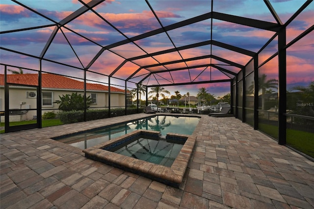 1801 Los Alamos Dr, Punta Gorda, FL 33950 - pool at dusk featuring a patio area, a pool with connected hot tub, and a lanai