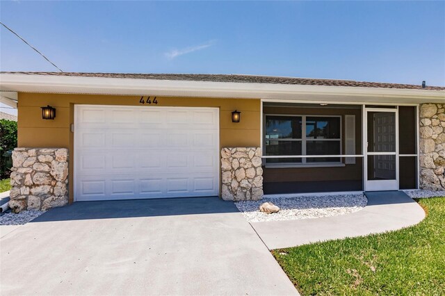 444 Edgewood Rd, Venice, FL 34293 - ranch-style home with stone siding, driveway, and an attached garage