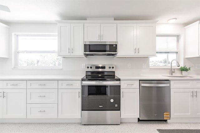444 Edgewood Rd, Venice, FL 34293 - kitchen with appliances with stainless steel finishes, white cabinetry, light countertops, and dark aggregate flooring