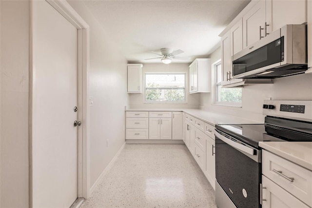 444 Edgewood Rd, Venice, FL 34293 - kitchen with stainless steel appliances, white cabinets, ceiling fan, and light countertops
