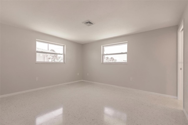 444 Edgewood Rd, Venice, FL 34293 - empty room with speckled floor and plenty of natural light