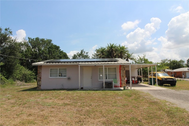 28024 Cleveland Ave, Punta Gorda, FL 33982 - view of front facade featuring driveway, a front yard, stucco siding, and roof mounted solar panels