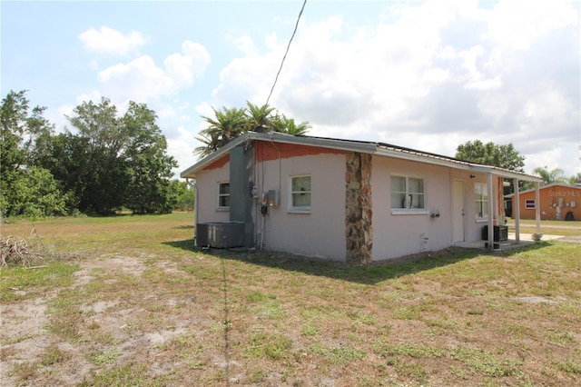 28024 Cleveland Ave, Punta Gorda, FL 33982 - view of side of property featuring central AC, stucco siding, and a lawn