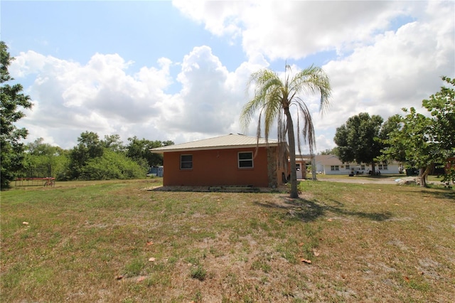 28024 Cleveland Ave, Punta Gorda, FL 33982 - view of side of property with a lawn and metal roof