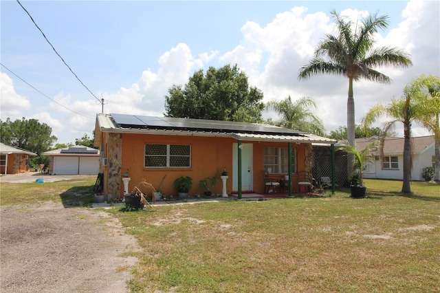 28024 Cleveland Ave, Punta Gorda, FL 33982 - view of front of home featuring stucco siding, a front lawn, roof mounted solar panels, and driveway
