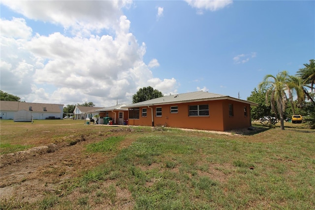 28024 Cleveland Ave, Punta Gorda, FL 33982 - rear view of property featuring a lawn and stucco siding