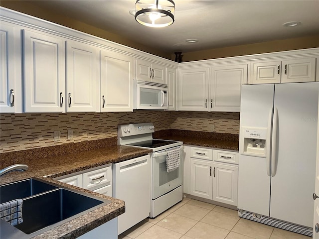 3300 Loveland Blvd Unit 602, Punta Gorda, FL 33980 - kitchen with white appliances, light tile patterned floors, white cabinets, dark countertops, and decorative backsplash