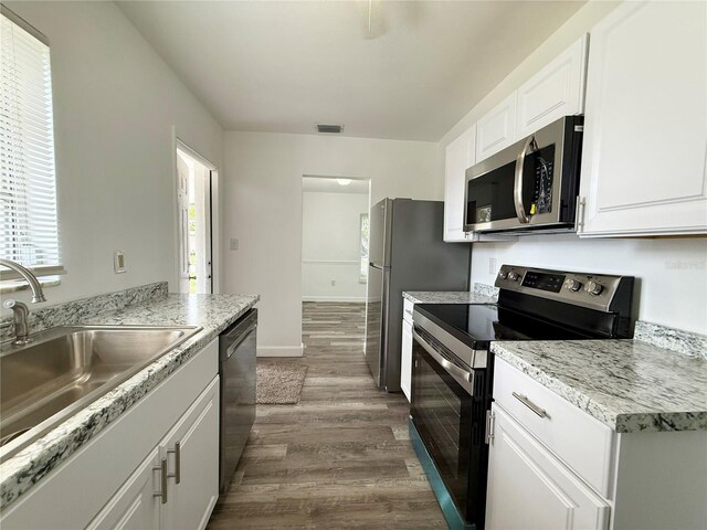 21899 Cellini Ave, Port Charlotte, FL 33952 - kitchen with stainless steel appliances, dark wood-style flooring, white cabinets, and light countertops