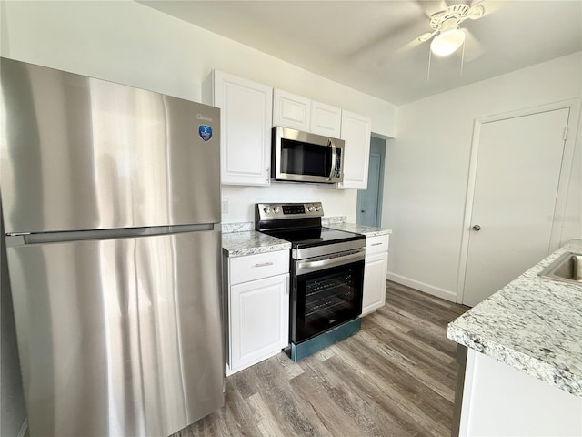 21899 Cellini Ave, Port Charlotte, FL 33952 - kitchen with stainless steel appliances, wood finished floors, white cabinets, and a ceiling fan