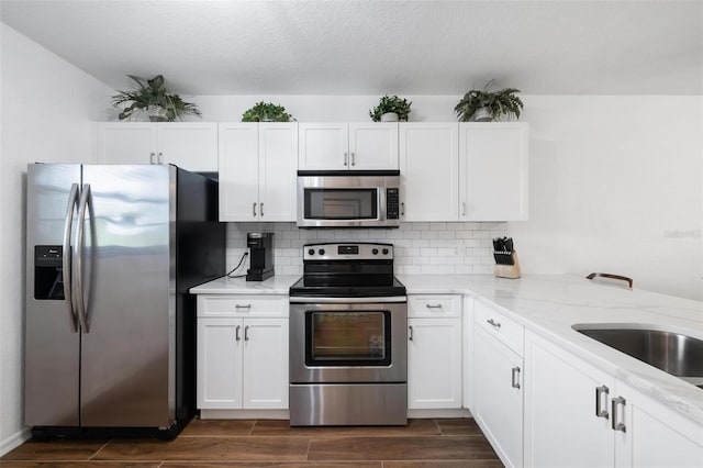175 Kings Hwy Unit 625, Punta Gorda, FL 33983 - kitchen with appliances with stainless steel finishes, wood finish floors, light stone counters, and white cabinets