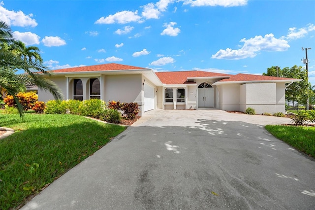2223 SE 10th Ln, Cape Coral, FL 33990 - ranch-style home featuring a garage, driveway, stucco siding, and a front lawn
