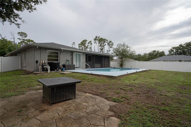 21220 Pemberton Ave, Port Charlotte, FL 33952 - back of house featuring a sunroom, a patio area, stucco siding, and an outdoor fire pit