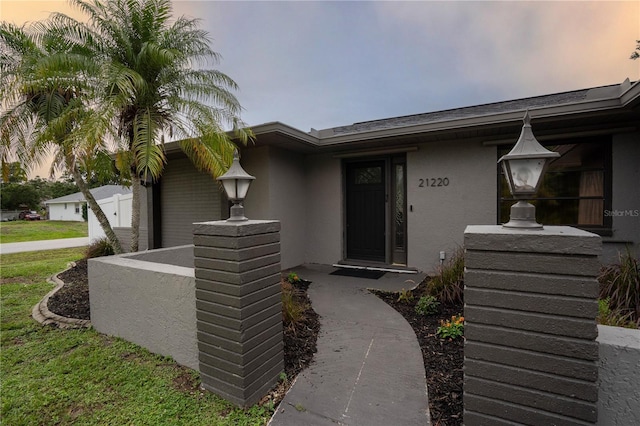21220 Pemberton Ave, Port Charlotte, FL 33952 - exterior entry at dusk with stucco siding