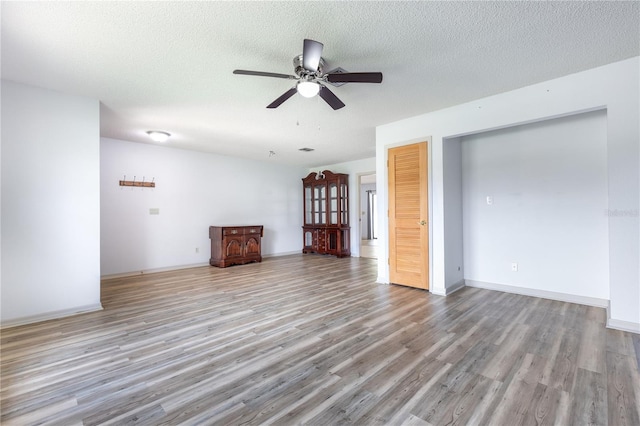 3242 Nocturne Rd, Venice, FL 34293 - unfurnished living room with light wood-style flooring, a ceiling fan, and a textured ceiling