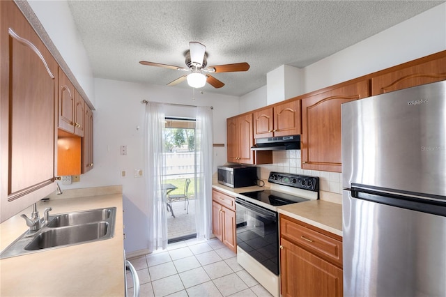 3242 Nocturne Rd, Venice, FL 34293 - kitchen featuring stainless steel appliances, under cabinet range hood, light countertops, a ceiling fan, and backsplash