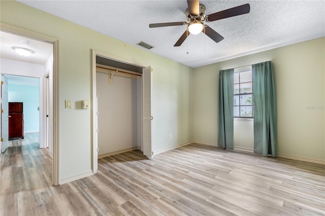 3242 Nocturne Rd, Venice, FL 34293 - unfurnished bedroom featuring light wood-style floors, a closet, a textured ceiling, and ceiling fan