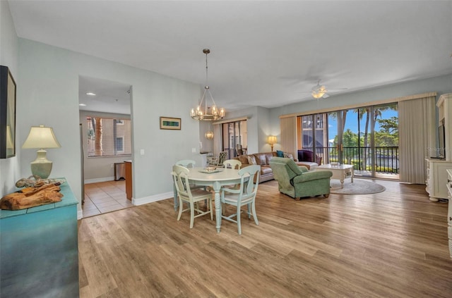 90 Vivante Blvd Unit 202, Punta Gorda, FL 33950 - dining area with light wood-style flooring, a ceiling fan, and a chandelier