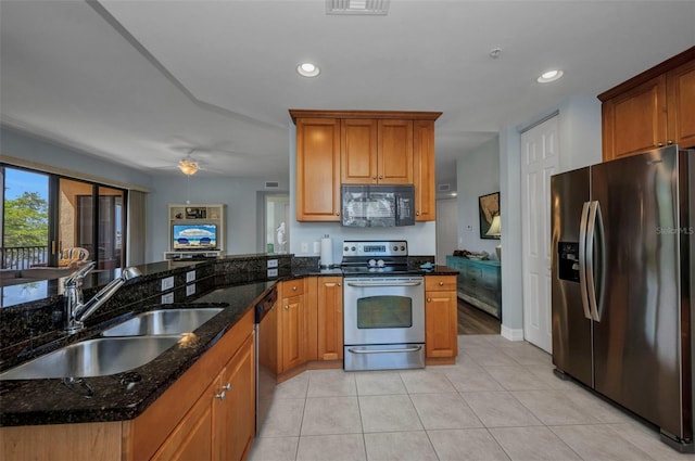 90 Vivante Blvd Unit 202, Punta Gorda, FL 33950 - kitchen with appliances with stainless steel finishes, light tile patterned floors, dark stone countertops, recessed lighting, and brown cabinetry