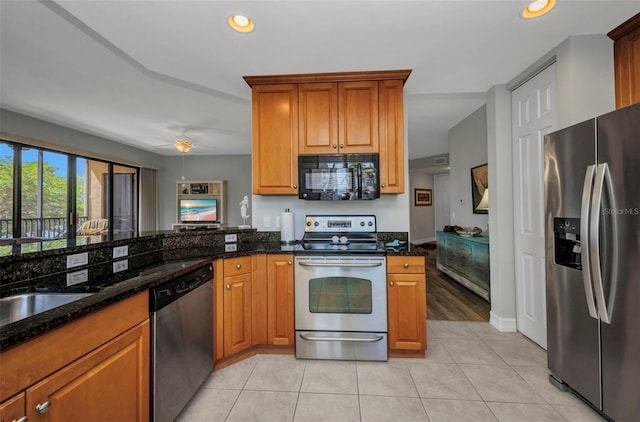 90 Vivante Blvd Unit 202, Punta Gorda, FL 33950 - kitchen featuring appliances with stainless steel finishes, a ceiling fan, dark stone countertops, brown cabinetry, and recessed lighting