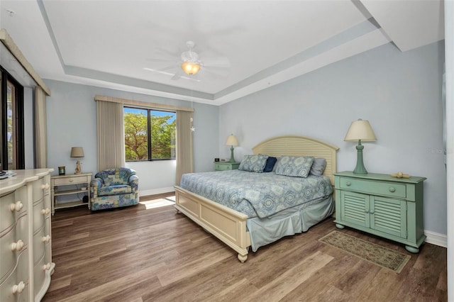 90 Vivante Blvd Unit 202, Punta Gorda, FL 33950 - bedroom with a tray ceiling, wood finished floors, and a ceiling fan