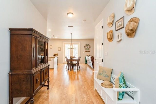 7424 Acorn Blvd, Punta Gorda, FL 33982 - corridor with light wood-style floors, a chandelier, and baseboards