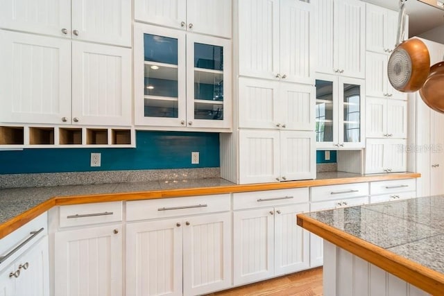 7424 Acorn Blvd, Punta Gorda, FL 33982 - kitchen with white cabinets, tile countertops, glass insert cabinets, and light wood-style flooring