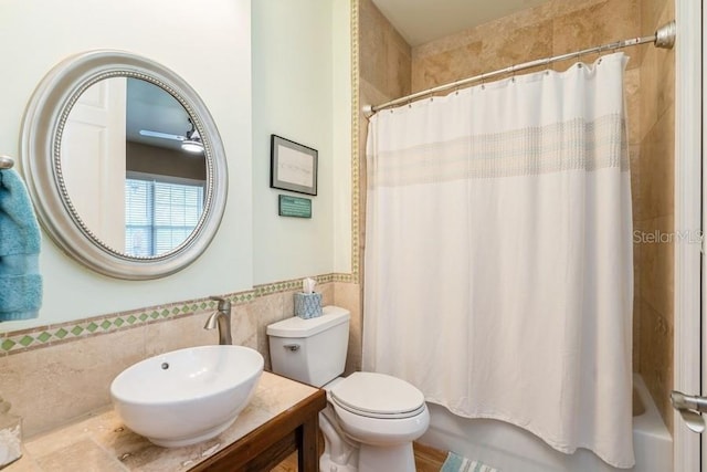 7424 Acorn Blvd, Punta Gorda, FL 33982 - bathroom with tile walls, toilet, shower / bath combo with shower curtain, vanity, and a wainscoted wall