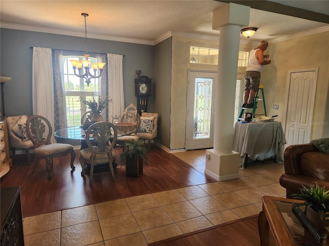 17150 Sarong Ln, Punta Gorda, FL 33955 - dining room with tile patterned floors, a chandelier, ornate columns, and crown molding