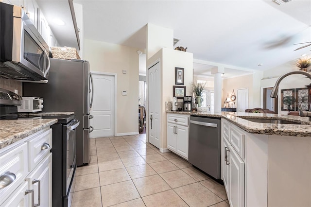 17150 Sarong Ln, Punta Gorda, FL 33955 - kitchen with stainless steel appliances, white cabinetry, light tile patterned flooring, and light stone counters
