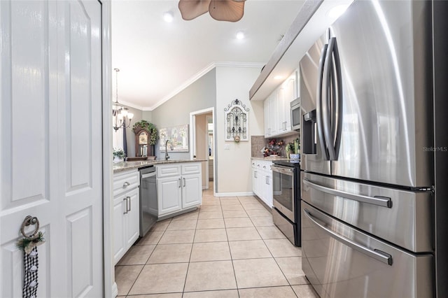 17150 Sarong Ln, Punta Gorda, FL 33955 - kitchen with appliances with stainless steel finishes, ornamental molding, white cabinets, backsplash, and light tile patterned floors