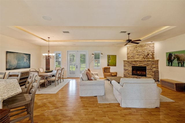 5221 Blackjack Cir, Punta Gorda, FL 33982 - living room with a raised ceiling, light wood-style flooring, a chandelier, and a stone fireplace
