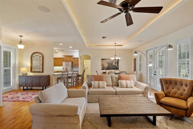 5221 Blackjack Cir, Punta Gorda, FL 33982 - living area featuring arched walkways, a raised ceiling, a ceiling fan, light wood-style floors, and a chandelier