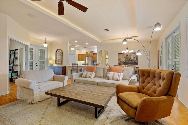 5221 Blackjack Cir, Punta Gorda, FL 33982 - living area featuring ceiling fan, light wood-style flooring, arched walkways, a chandelier, and a raised ceiling