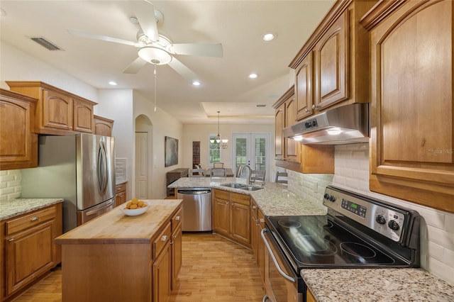 5221 Blackjack Cir, Punta Gorda, FL 33982 - kitchen with stainless steel appliances, wood counters, under cabinet range hood, light wood-style flooring, and a peninsula