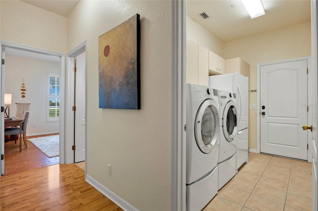 5221 Blackjack Cir, Punta Gorda, FL 33982 - laundry area with washing machine and dryer, light wood finished floors, and cabinet space