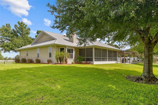 5221 Blackjack Cir, Punta Gorda, FL 33982 - back of property with a yard, a sunroom, a chimney, and a metal roof