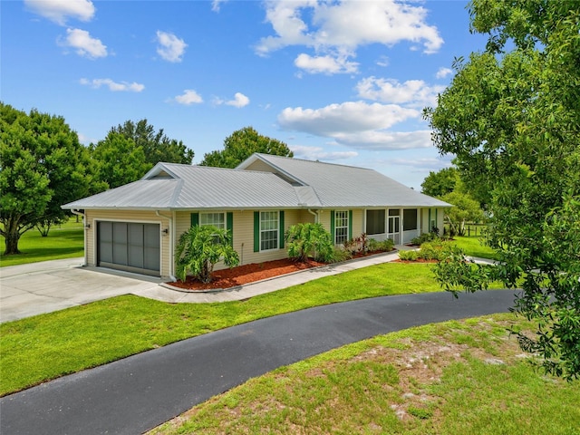 5221 Blackjack Cir, Punta Gorda, FL 33982 - ranch-style home with driveway, a garage, a front lawn, and a metal roof