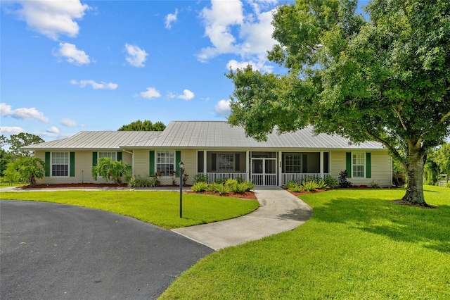 5221 Blackjack Cir, Punta Gorda, FL 33982 - ranch-style house with a front yard, a metal roof, and a porch