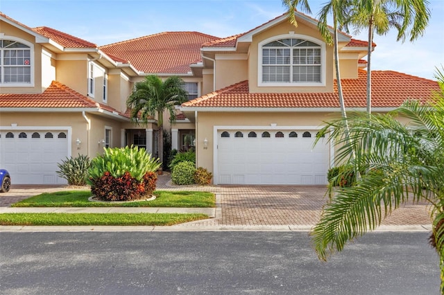 2630 Tarpon Cove Dr Unit 212, Punta Gorda, FL 33950 - view of front facade with a tiled roof, decorative driveway, stucco siding, and an attached garage