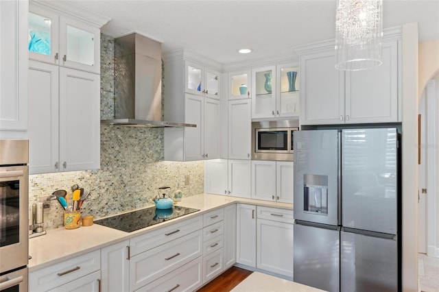 2630 Tarpon Cove Dr Unit 212, Punta Gorda, FL 33950 - kitchen featuring stainless steel appliances, wall chimney range hood, white cabinetry, light countertops, and decorative backsplash
