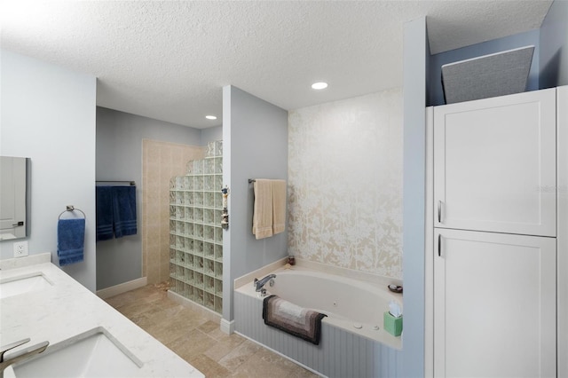2630 Tarpon Cove Dr Unit 212, Punta Gorda, FL 33950 - bathroom with a whirlpool tub, walk in shower, a textured ceiling, double vanity, and recessed lighting